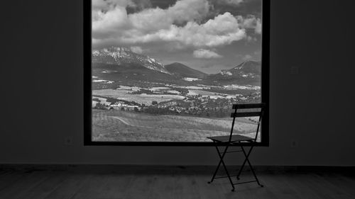 Scenic view of landscape against sky seen through window