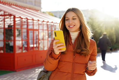 Portrait of young woman using mobile phone