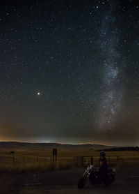 People sitting against sky at night