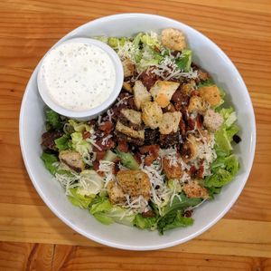 Salad with croutons, bacon, cheese, and ranch dressing