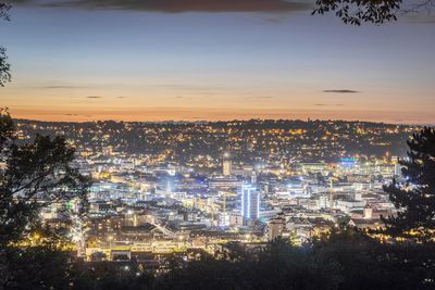 High angle view of city lit up at sunset