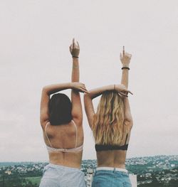 Rear view of couple standing against sky