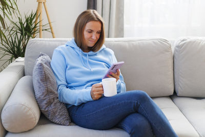 Portrait of woman sitting on sofa at home