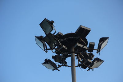 Low angle view of camera against clear blue sky