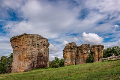 View of rock formation on field against sky