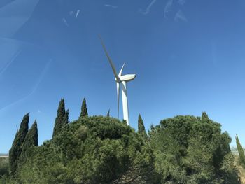 Low angle view of windmill against clear blue sky