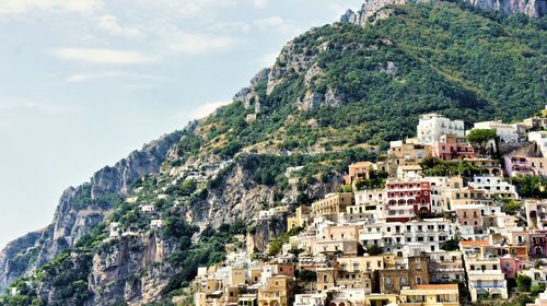 Aerial view of town by mountain against sky