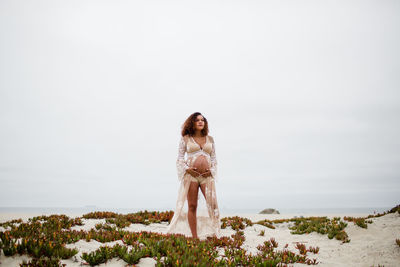 Young pregnant woman posing on beach