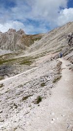 Rear view of people walking on land against sky