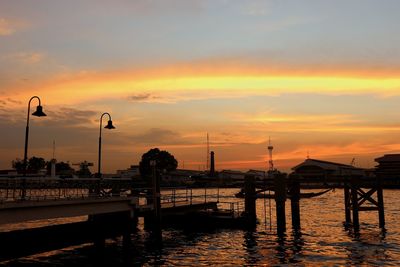 Silhouette pier on street against sky during sunset