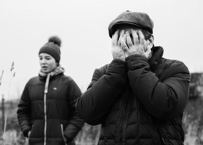 Frustrated father standing with daughter in background