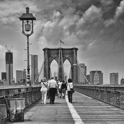 Rear view of people on footbridge in city