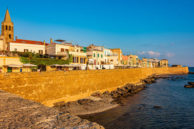 Buildings at beach against blue sky