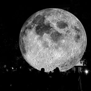 Low angle view of illuminated moon against sky at night