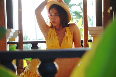 Portrait of beautiful woman wearing hat sitting indoors