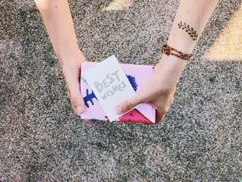 Low section of woman holding paper with text