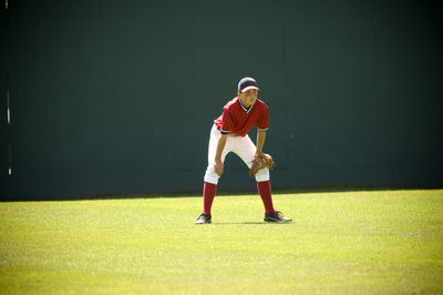 Boy in ready position in the outfield of a baseball field