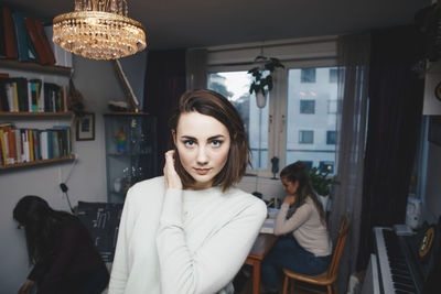 Portrait of young woman with friend sittings in college dorm room