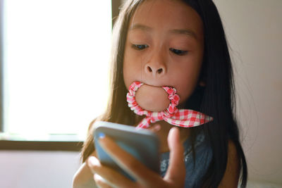 Portrait of girl holding mobile phone