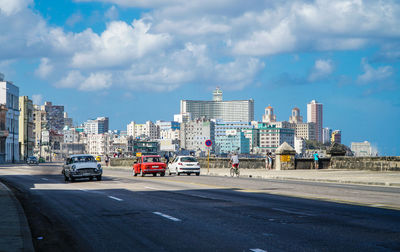 Vehicles on road against buildings in city