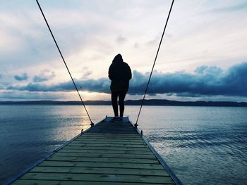 Rear view of man standing on pier