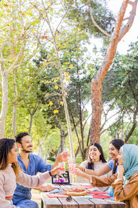 Portrait of smiling friends sitting in park