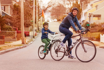 Portrait of son riding bicycle with father