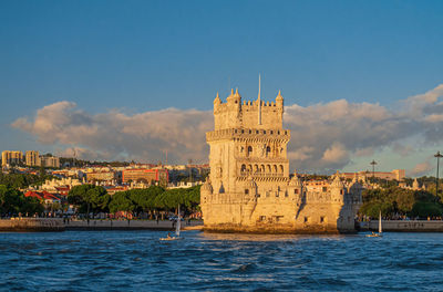 Castle by sea against sky in city