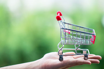 Close-up of woman holding figurine shopping cart 