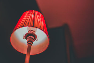 Low angle view of illuminated lamp in darkroom