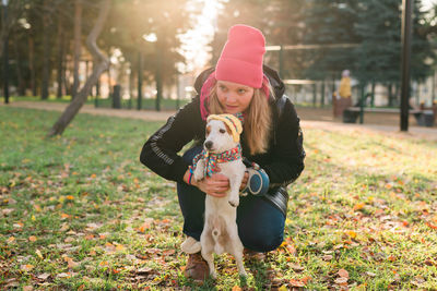 Young woman with dog running on field