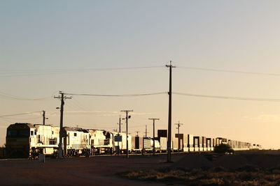Electricity pylon against clear sky during sunset
