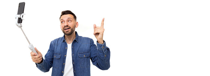 Low angle view of man with arms raised against white background