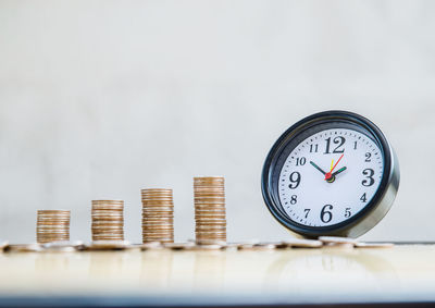 Close-up of coins on table against wall