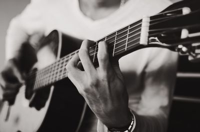 Midsection of man playing guitar