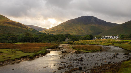 Scenic view of river amidst mountains against sky