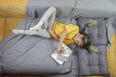 High angle view of girl lying on bed at home