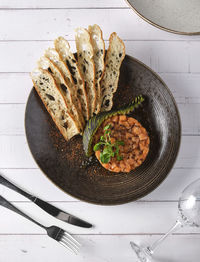 Gourmet fish tartar raw from tuna fillet with hashed avocado, selective focus