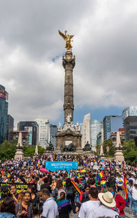 People at town square against sky in city