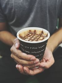 A man holding a paper cup of coffee