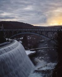 Bridge over river against sky during sunset