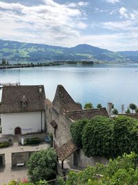 Scenic view of lake by buildings against sky