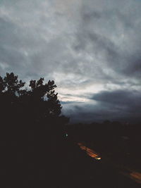 Silhouette trees against sky at dusk