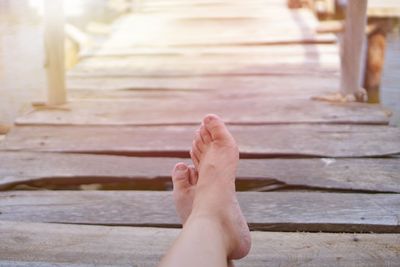 Low section of woman relaxing on wood