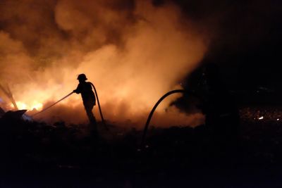 Silhouette man standing against sky at night