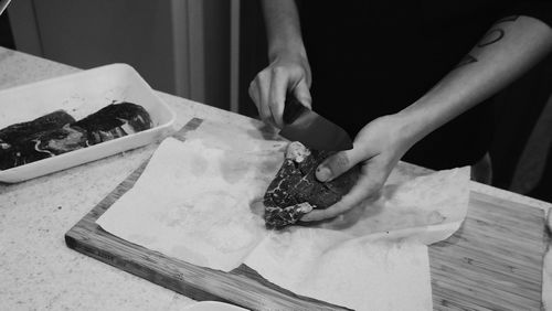 Midsection of woman preparing food on cutting board