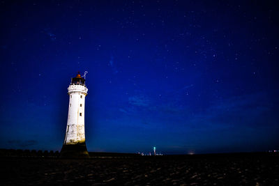 Low angle view of lighthouse against sky at night