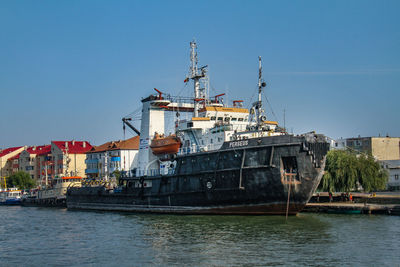 Cranes at harbor against clear blue sky