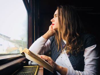 Close-up of woman looking through window