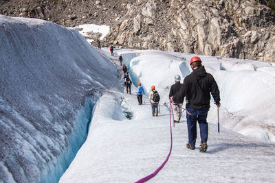 Tourists hiking on snow covered landscape